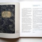 1. Band der Chronik von 1898 bis 1928 der Baugenossenschaft München des Bayerischen Eisenbahner Verbandes. Links ein Notizbuch.