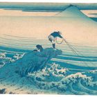 Japanische Schriftzeichen oben links. Zwei Fischer auf Felsen, wilde Wellen, im Hintergrund ein Berg, vermutlich der Fuji.