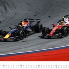 August, Monatskalender mit Rennsportmotiven. Zwei Formel-1-Wagen in Kurve, einer blau, der andere rot, auf der Rennstrecke.