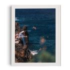 Kein Text. Menschen springen von Klippen ins blaue Meer. Einige schwimmen, andere stehen auf den Felsen.