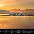 "Lofoten 08; Fiskenel, Austvågøya". Abendstimmung mit Wasser, Booten, Hütten und Bergen im Hintergrund.