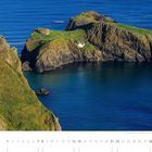Text: "Die Hängebrücke zur Insel Carrick-a-Rede an der Antrim Coast, County Antrim." Grüne Insel mit Hängebrücke über blauem Meer.