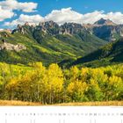 "Owl Creek Pass im Uncompahgre National Forest (Colorado)." Herbstwald vor imposanten, zerklüfteten Bergen und blauem Himmel.