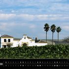 "Andalusien 08" und ein Kalender für August. Weiße Finca, Palmen, Hügel und blauer Himmel mit Wolken.