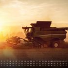 Kalender mit August-Daten. Ein Mähdrescher auf einem Feld bei Sonnenuntergang, hinterlässt Staub in der Luft.
