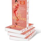 Buchtitel: "Les Bouttiers". Autorin: Antonia Wesseling. Illustration: Frau im eleganten roten Kleid. Stapel Bücher.
