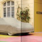 "Heidi Horten Collection" steht auf einer gelben Wand. Eine Skulptur eines Autos ist von einer Steinabdeckung umhüllt.