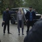 Zwei Männer halten eine Frau fest, einer richtet eine Waffe auf ihren Kopf. Ein Geländewagen steht im Hintergrund.