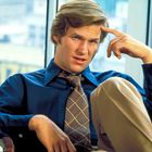 Ich kenne die Person nicht. Ein junger Mann in blauem Hemd und gemusterter Krawatte sitzt entspannt vor einem Fenster.