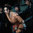 Ich kann keine Personen beschreiben. Eine Frau wird von drei Männern in traditionellen Gewändern festgehalten.