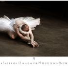 Kalender mit Zahlen 1 bis 30, darunter eine Ballerina in weißem Tutu auf einem dunklen Boden.