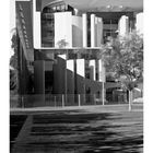 "Kanzleramt", Monatskalender, Tage 1-30. Modernes Gebäude aus Beton und Glas, Bäume im Vordergrund.