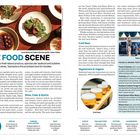 "THE FOOD SCENE" in großen Buchstaben. Fokus auf Essen in Tasmanien: frische Produkte, Meeresfrüchte und Weine. Mehrere Teller mit verschiedenen Gerichten.