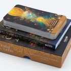 "Das Orakel des Lichts." Ein Stapel Karten auf zwei Büchern mit mystischen Mustern.