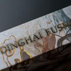 Text "DINGHAI FUSHENG" in goldener Schrift auf kunstvollem Hintergrund mit abstrakten Mustern in Blau, Gold und Braun.