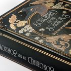 "SONGBIRD OF THE SORROWS" in kunstvoller Schrift auf einem Buchcover. Vögel und florale Muster verzieren das Design.