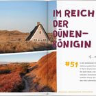 „IM REICH DER DÜNENKÖNIGIN“ – Ein Haus mit Strohdach steht in einer Dünenlandschaft im warmen Licht der untergehenden Sonne.