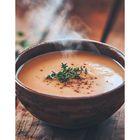 Zahl 34 unten links, eine dampfende Schüssel Suppe mit Kräutergarnitur und Pfefferkörnern in einer rustikalen Umgebung.