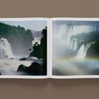 Ein offenes Buch zeigt zwei Seiten mit Fotografien von beeindruckenden Wasserfällen und üppiger, grüner Vegetation.