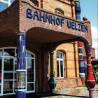 "Bahnhof Uelzen" steht auf einem verspielten, bunten Gebäude mit runden Säulen. Unten ist ein Kalenderblatt für den September.