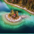 Kalender: September. Eine kleine Insel mit Bäumen und einer Hütte in klarem, türkisfarbenem Wasser, umgeben von Wald.