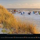 Kalender mit September; zeigt einen sonnigen Strand mit Dünen, vielen bunten Strandkörben, wenig Menschen im Hintergrund.