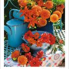 Kalenderblatt für September 2027. Bunte Blumenarrangements in Vasen, darunter eine Gießkanne auf einem Tisch mit Muster.