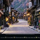 Kalendertext: September 2023. Traditionelle Straße mit Holzhäusern, leuchtenden Laternen und Pflanzen.