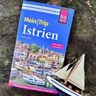 „Mein Trip Istrien“ und „Mit Ausflug nach Rijeka“ auf Reiseführer. Daneben ein kleines Modellboot.