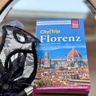 Reiseführer "CityTrip Florenz" von Daniela Schetar und Friedrich Köthe, daneben eine Spitzenmaske dekorativ arrangiert.