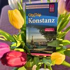 "CityTrip Konstanz" Reiseführer, umgeben von bunten Tulpen.