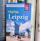Reiseführer mit dem Titel „CityTrip Leipzig“ von David Blum, vor Regalbrettern aufgestellt.