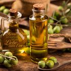 Zitat: „Keine Liebe ist aufrichtiger als die Liebe zum Essen.“ - George Bernard Shaw. Monat: September. Olivenölflaschen und Oliven.