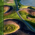 Text "9" und Zahlen von 01 bis 30 auf grünem Hintergrund. Landschaft mit grünen Hügeln und Kratern am Wasser.