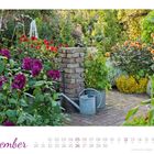 „September“ steht groß auf einem Kalenderblatt. Ein grüner Garten mit bunten Blumen und zwei Gießkannen ist abgebildet.