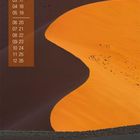 Kalender mit Zahlen 09 bis 30 links. Eine große, orange Düne im Hintergrund und ein einzelner Baum im Vordergrund.