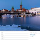 05. Woche, Februar 2027. Verschneite Brücke, Altstadt mit Kirchtürmen im Hintergrund.