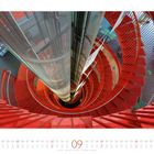 09. Ein rotes spiralförmiges Treppenhaus von oben fotografiert, mit einem zentralen Aufzugsschacht.