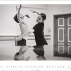 Zwei Tänzer in eleganter Pose in einem Tanzstudio, reflektiert auf dem Boden. Darunter eine Monatsübersicht mit Zahlen von 1 bis 30.