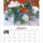 Text: "September." Darunter ein Kalender. Oben Zierkürbisse, grüne Blätter und bunte Blumen in hellem Behälter.
