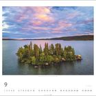 Kalenderblatt für September. Kleine, bewaldete Insel in einem See, umgeben von einem dramatischen Himmel bei Sonnenuntergang.