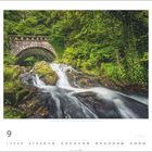 Text: "Cloghoge Bridge, Wicklow Mountains Nationalpark, County Wicklow." Ein Fluss fließt unter einer Steinbrücke inmitten von üppigem Grün.