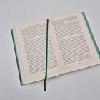 Offenes Buch mit Text in Deutsch, Seitenzahl 135 unten rechts, grünes Lesezeichen in der Mitte.