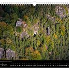 „September“ und Kalendarium unten. Oben: Hütte auf Felsen, umgeben von dichtem Wald.