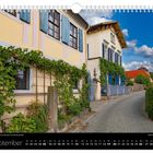 Kalenderblatt mit dem Monat "September", Bild zeigt malerische Häuser mit blauen Fensterläden und üppigem Weinbewuchs.