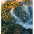 "09" und Kalendertage unten, "Über dem Großen Winterberg" rechts. Herbstlicher Wald mit Nebel darüber aus der Vogelperspektive.