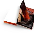 Eine blonde Frau auf einer Buchseite, darunter eine stilisierte Burglandschaft in Rot- und Schwarztönen.