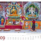 09, Kalender mit Bildern von buddhistischen Statuen. Person bei farbenfrohem Schrein in Gebetshaltung.