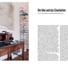 „Die Idee und das Einarbeiten. Vom ersten Bauchgefühl zum kulturgeschichtlichen Hintergrund.“ Links Schreibtisch mit Laptop, Karte. Rechts hohe Bücherstapel.