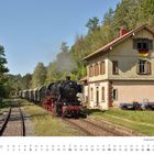 „SEPTEMBER“ und „Güterzug-Einheitslokomotive der Baureihe 50“ sind zu lesen. Eine Dampflok neben einem Bahnhofsgebäude.